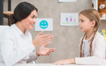 Speech therapist communicating with a young child to assess signs of late talker