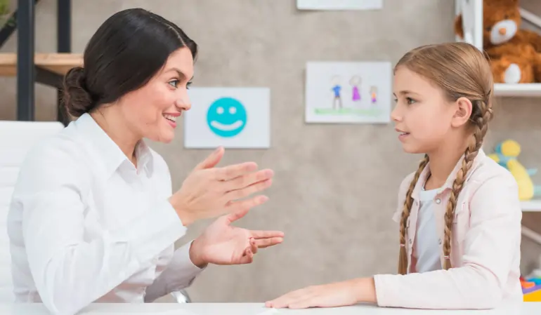 Speech therapist communicating with a young child to assess signs of late talker