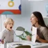 Speech therapist helping a child practice expressive and receptive language skills using a mirror during a speech therapy session