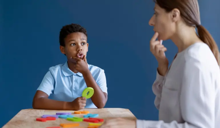Child practicing expressive and receptive language skills with a speech therapist using a mirror