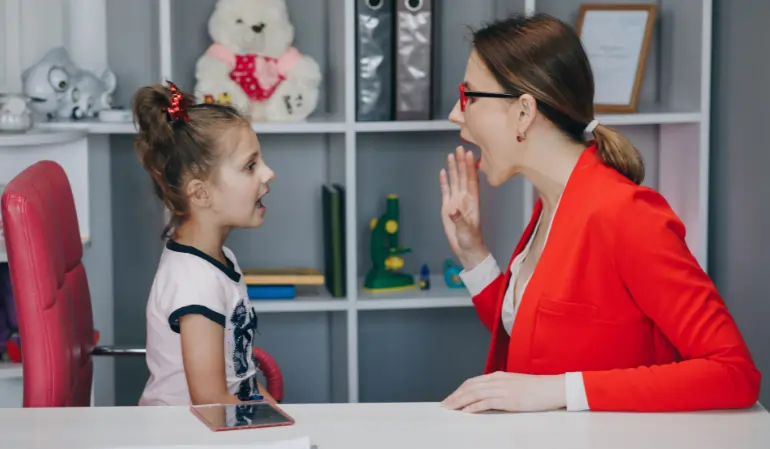 Speech therapist helping a young child practice pronunciation during a speech therapy session
