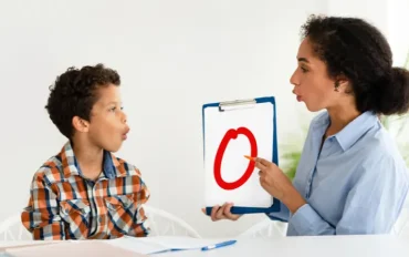 Speech therapist conducting a communication and language assessment with a child at a child assessment center using visual learning tools.