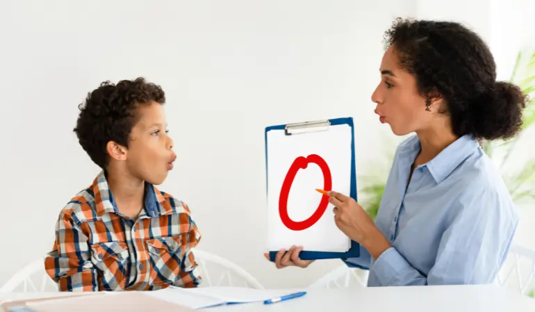 Speech therapist conducting a communication and language assessment with a child at a child assessment center using visual learning tools.