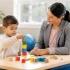Child stacking blocks with therapist during ABA therapy session